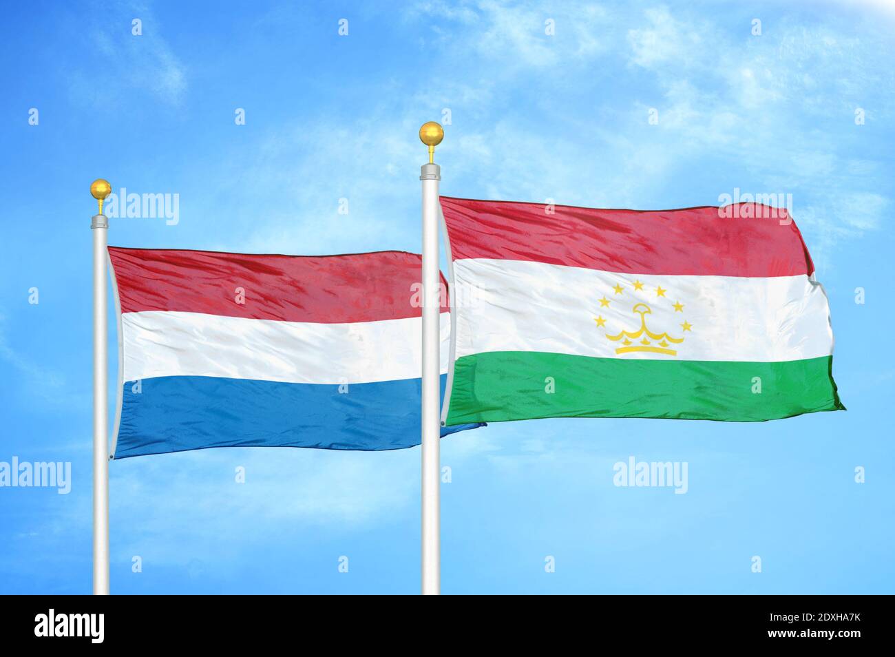 Paesi Bassi e Tagikistan due bandiere su pali e cielo blu Foto Stock