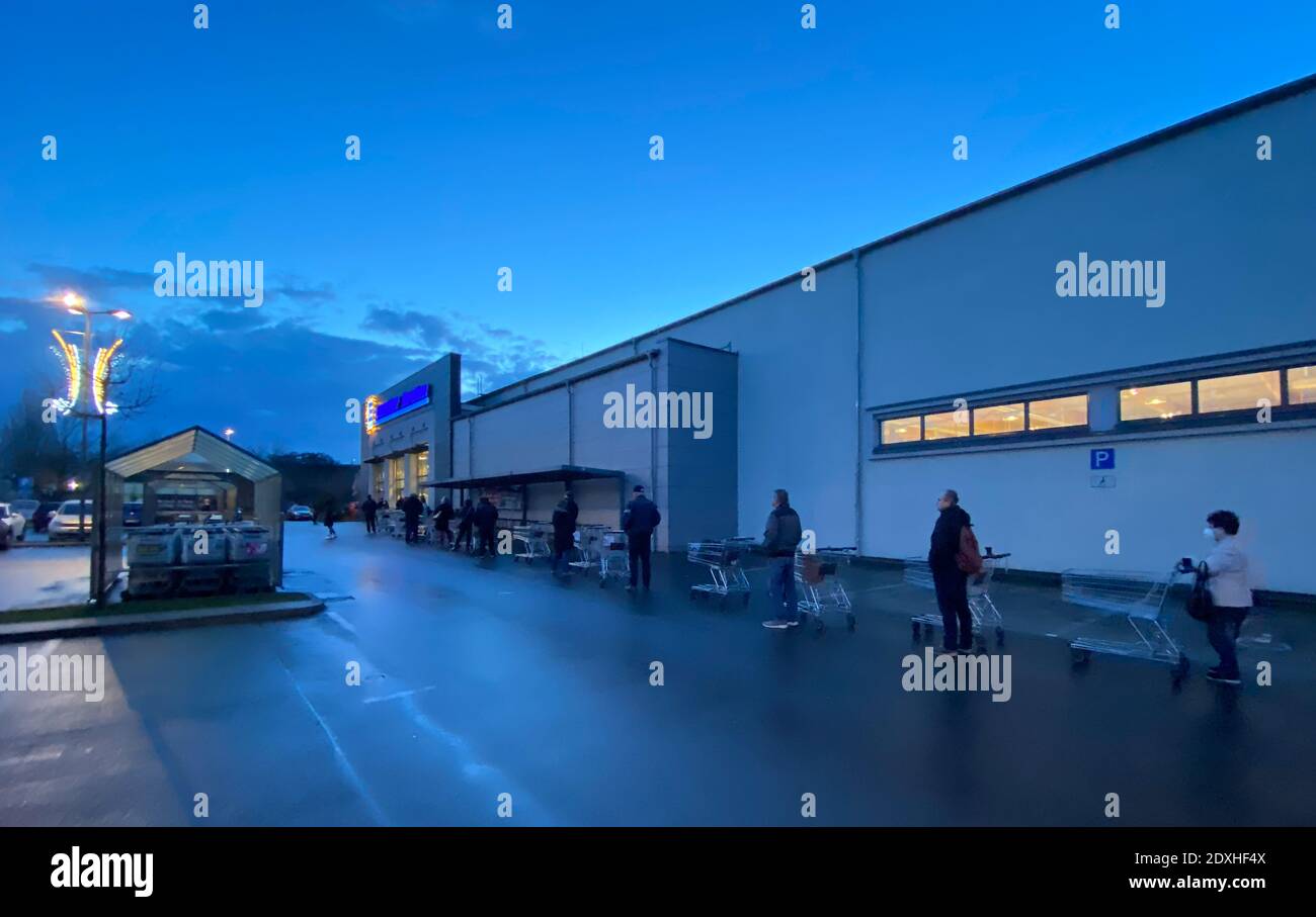 Berlino, Germania. 24 Dic 2020. La gente accoda fuori di un ramo di una catena del supermercato per fare il loro shopping di Natale. Credit: Paul Zinken/dpa/Alamy Live News Foto Stock