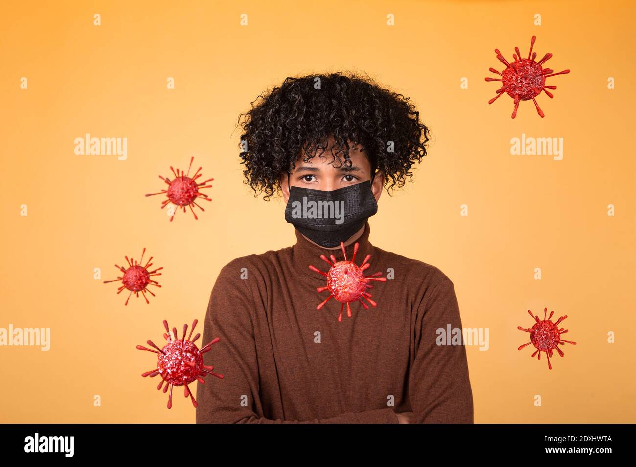 Ritratto di ragazzo afro con maschera medica su sfondo giallo con molecole batteriche. Epidemia, virus, salute. Spazio di copia Foto Stock