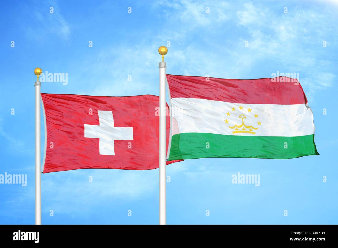 La Svizzera e il Tagikistan due bandiere su pali e cielo blu Foto Stock