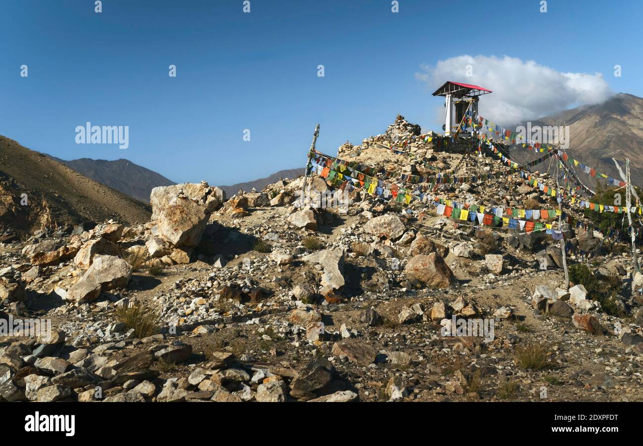 Ruota di preghiera buddista sotto l'alloggio sulla cima della montagna nell'Himalaya e cielo blu luminoso in mezzo al paesaggio naturale. Nako, Himachal Pradesh, India. Foto Stock