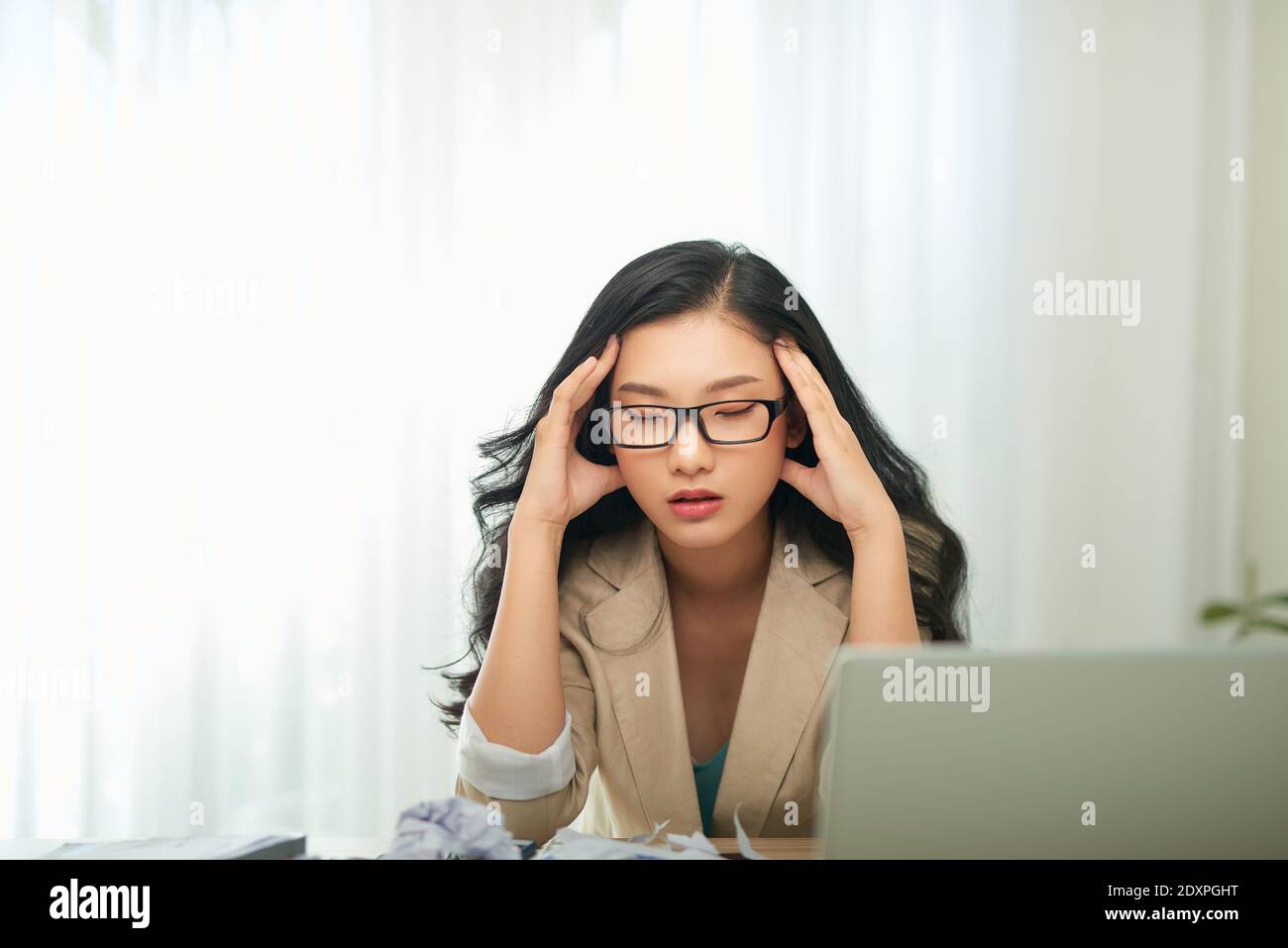 Giovane e bella donna d'affari stanca dal lavoro in ufficio Foto Stock