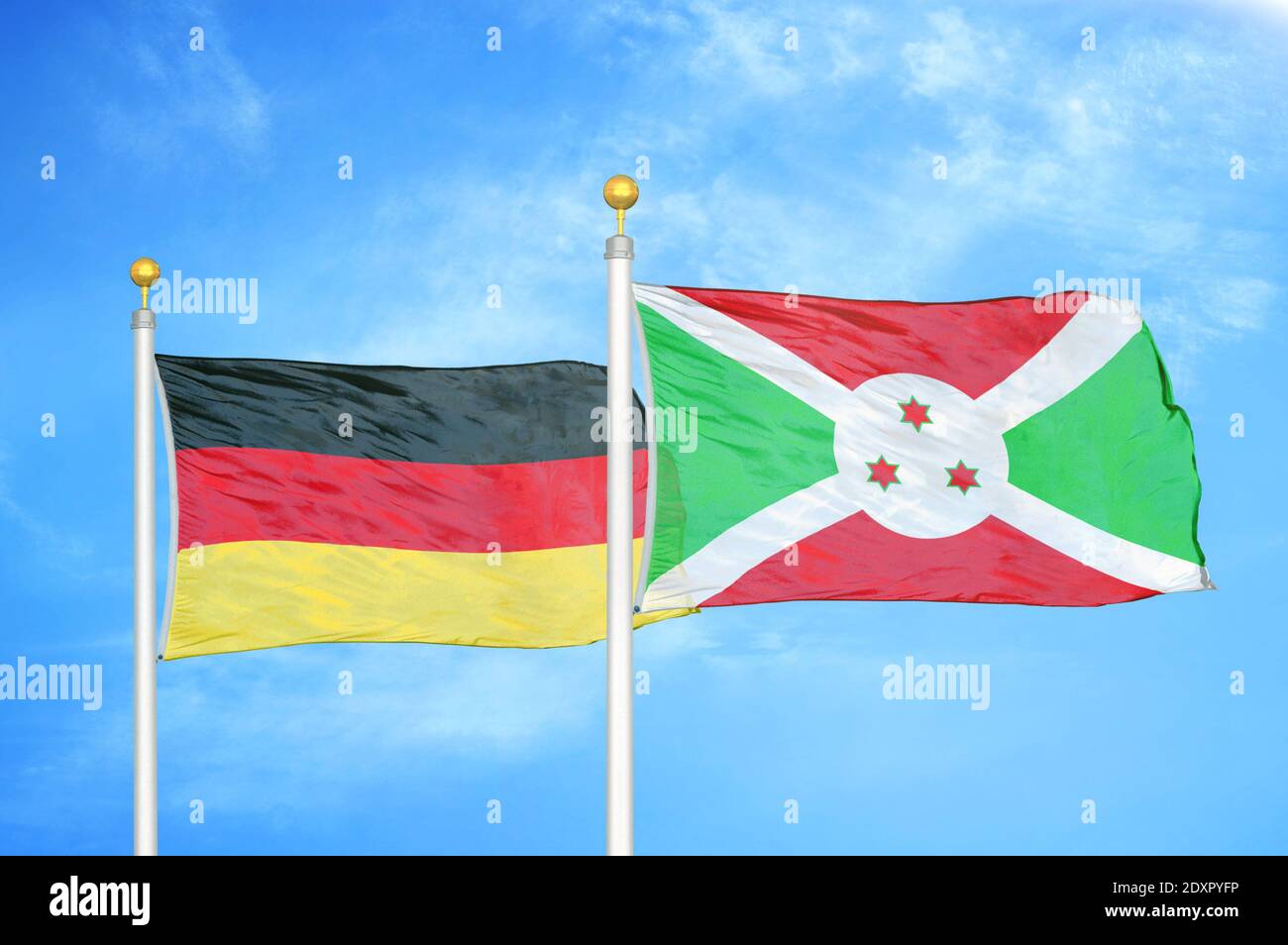 Germania e Burundi due bandiere su paletti e blu nuvoloso cielo Foto Stock