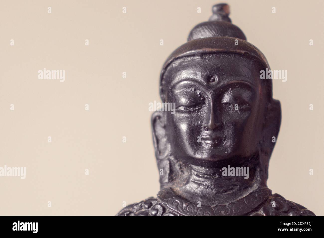 Primo piano di una statua di Buddha contro Set Sail Champagne colore (trend colore 2021) sfondo. Spazio di copia. Foto Stock