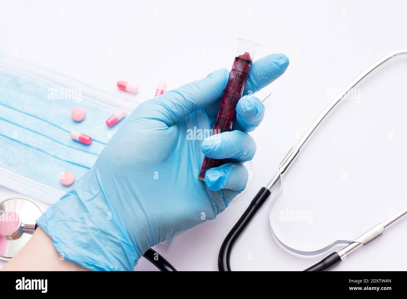 La mano di un medico in possesso di una bottiglia di campione di sangue Foto Stock