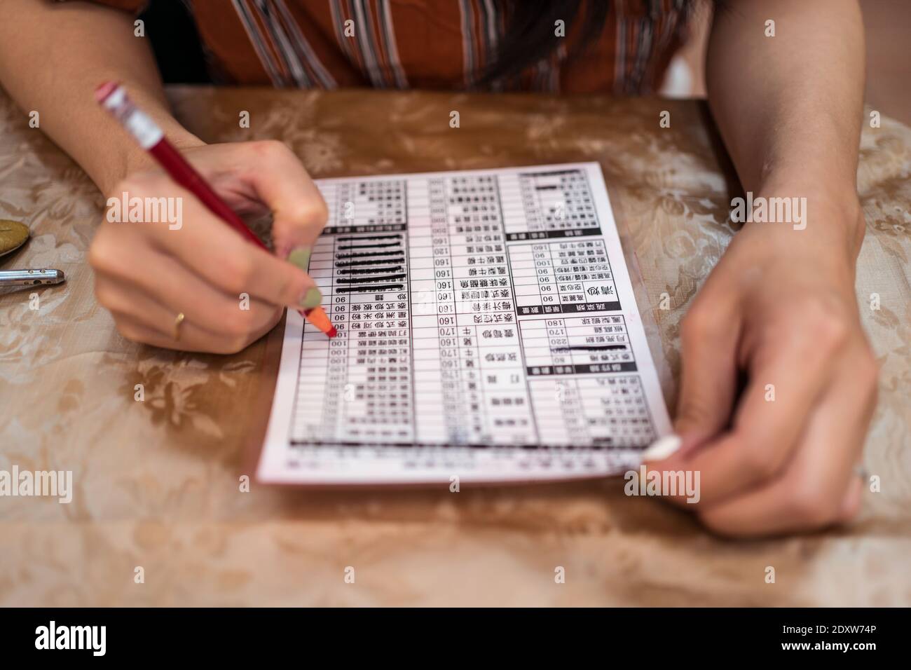 Dettaglio delle mani della giovane donna asiatica che guarda al ristorante Menu a Taiwan Foto Stock