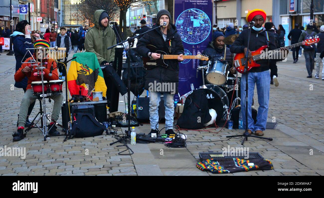 I musicisti si esibiscono nel centro città di Manchester, Greater Manchester, Inghilterra, Regno Unito la vigilia di Natale 2020. Foto Stock