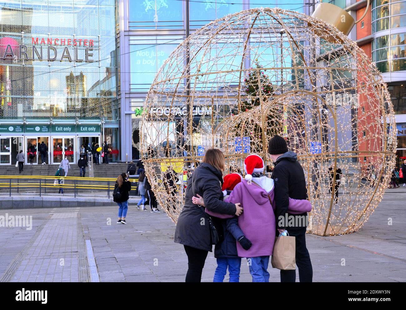 Decorazioni illuminate di fronte al centro commerciale Arndale nel centro della città di Manchester, Greater Manchester, Inghilterra, Regno Unito la vigilia di Natale, 2020 come gli acquirenti fare shopping ultimo minuto. Foto Stock