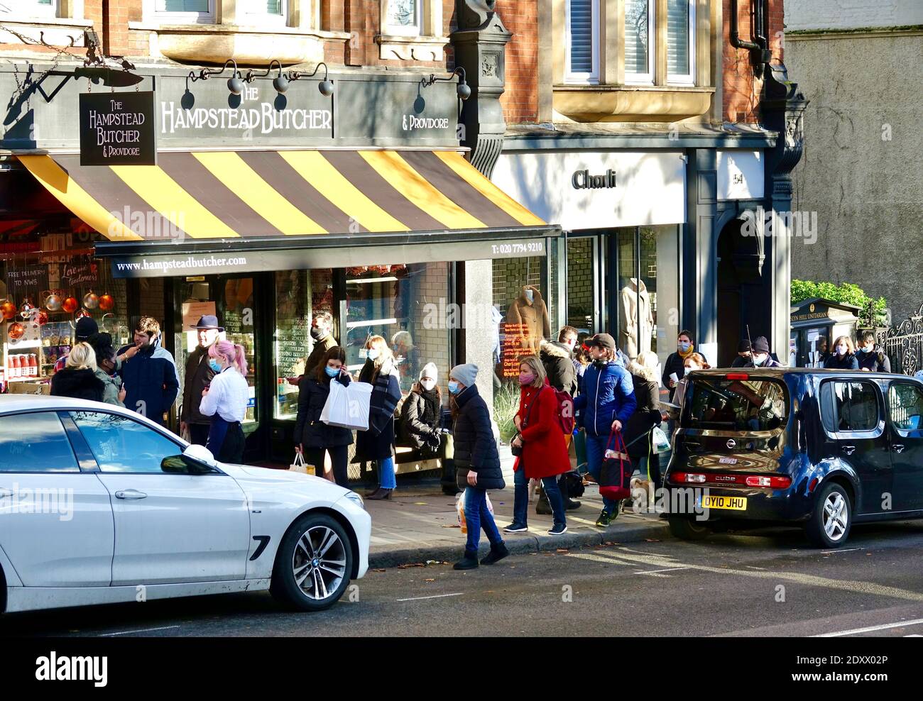 Hampstead Butcher e Providore con lunga coda la vigilia di Natale con gli acquirenti che cercano di acquistare cibo per il giorno di Natale 2020. Londra Foto Stock