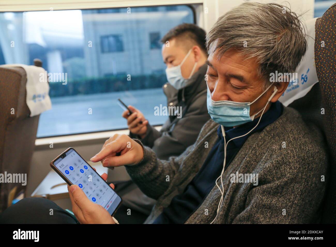 Shanghai, Cina. 24 Dic 2020. Un passeggero muta il suo cellulare sulla 'tranquilla auto' del G2 bullet train della ferrovia ad alta velocità Pechino-Shanghai, che collega Pechino, capitale della Cina, e Shanghai della Cina orientale, il 24 dicembre 2020. Alcuni treni ad alta velocità in Cina hanno pilotato 'vetture silenziose' per i passeggeri che optano per un'esperienza di viaggio tranquilla e indisturbata. La "Quiet car" è spesso la carrozza n. 3 sul treno, con video a bordo disattivati e annunci fatti a un volume inferiore. Le porte alle estremità del carrello saranno chiuse per ridurre il rumore proveniente dal vestibolo. Credit: Xinhua/Alamy Live News Foto Stock