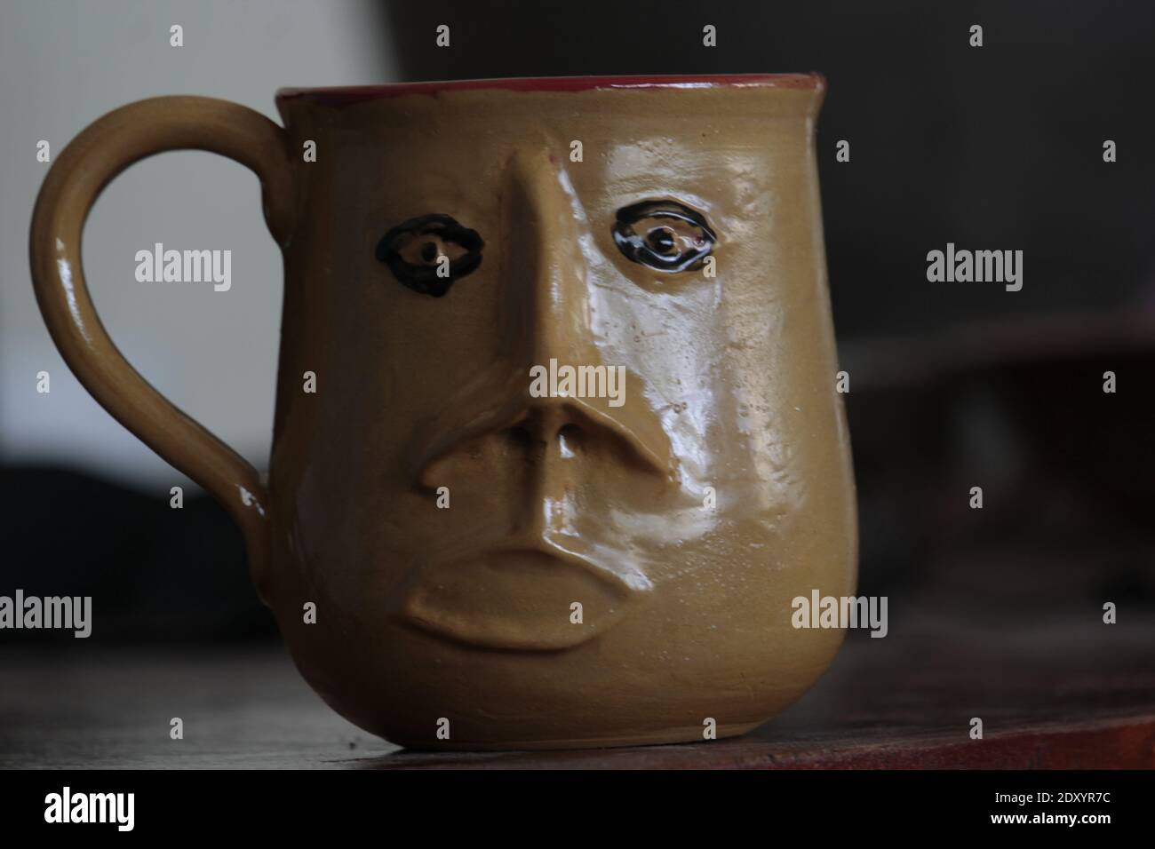 Un primo piano di una tazza di ceramica con un volto triste scultura Foto Stock