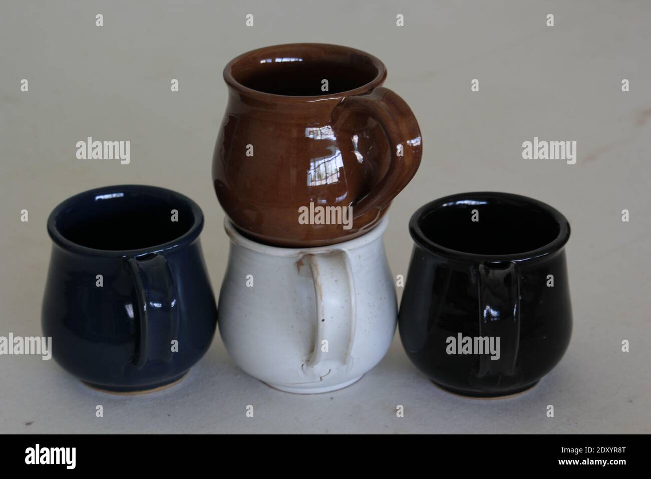 Un primo piano di tazze in ceramica su sfondo grigio Foto Stock