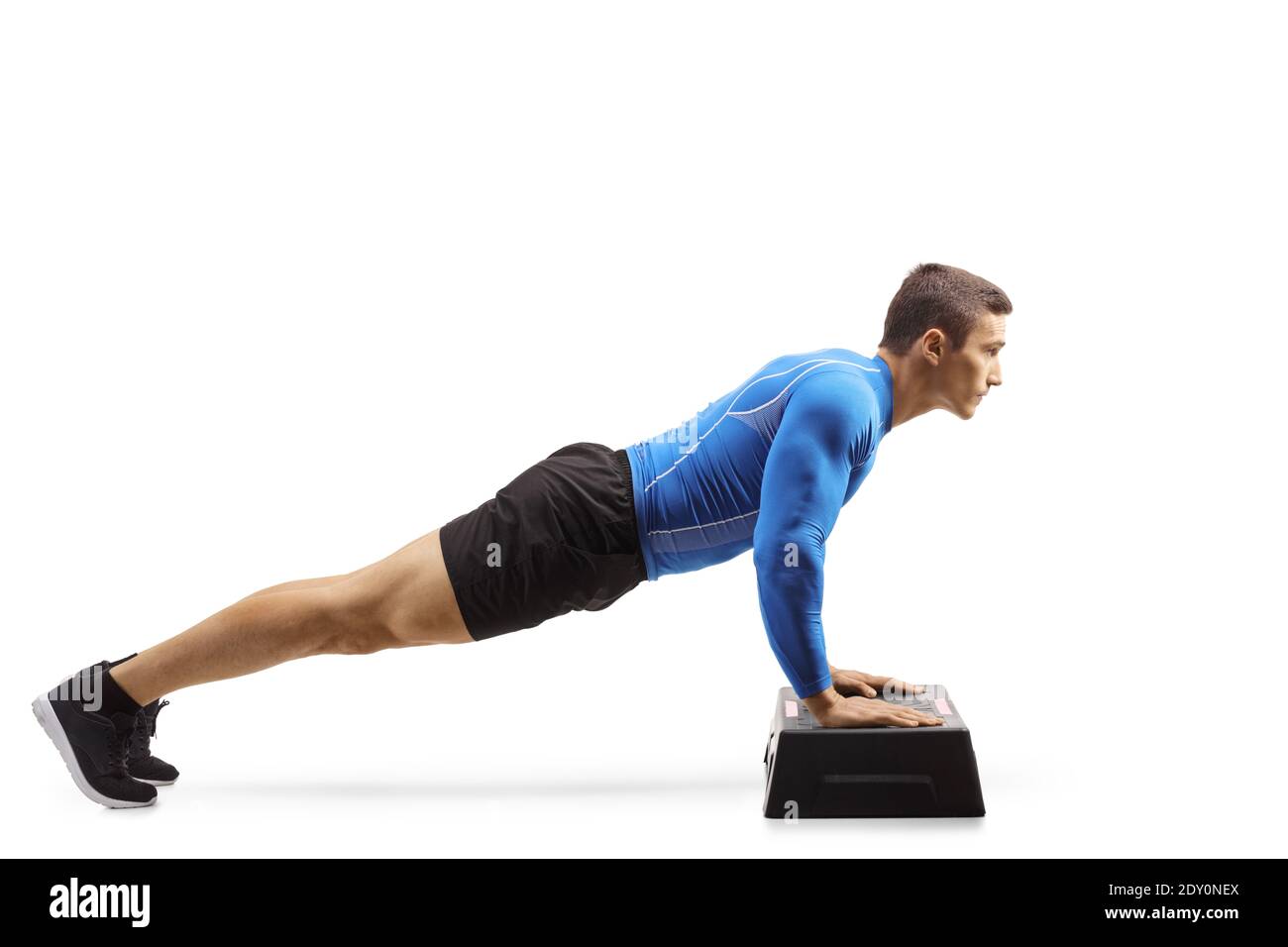 L'uomo muscolare che esercita i push-up su una piattaforma aerobica passo isolato su sfondo bianco Foto Stock