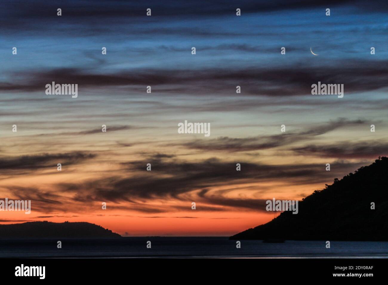 Vista panoramica del mare contro il cielo drammatico durante il tramonto Foto Stock