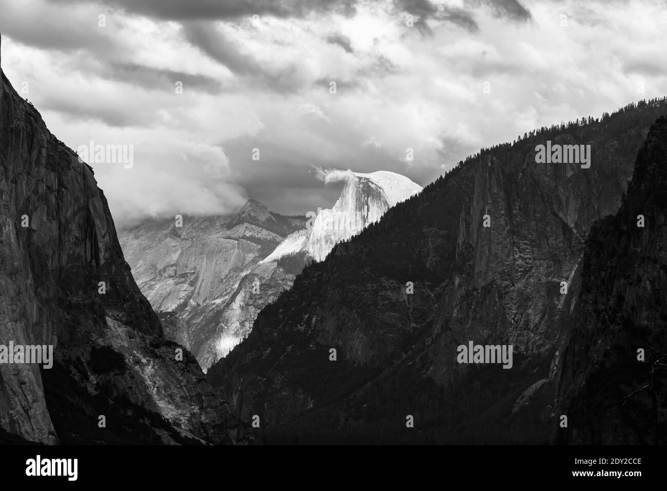 Vista a distanza di Half Dome e Cloud Rest ricoperti di nuvole in bianco e nero. Yosemite Valley, Yosemite National Park, High Sierra, California USA. Foto Stock