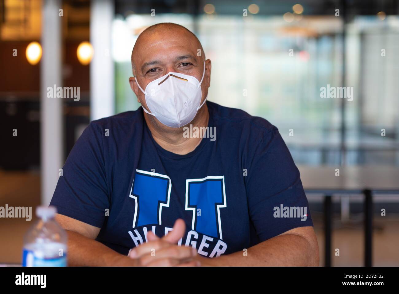 Uomo latino-americano sorridente dietro la maschera protettiva, Toronto, Canada Foto Stock