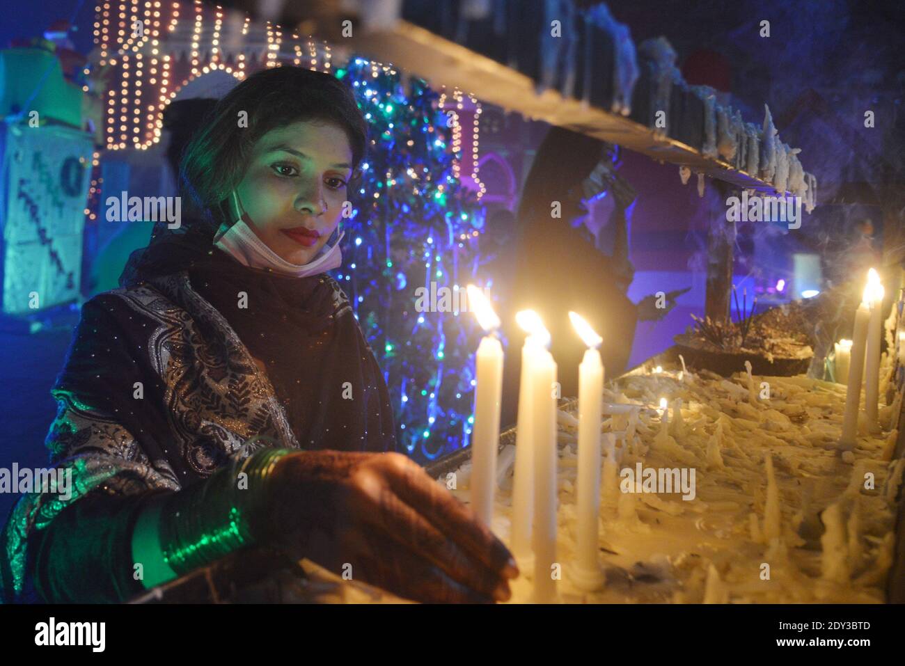 I cristiani pakistani adorano la messa di Natale di metà notte in vista delle celebrazioni natalizie nella Chiesa di Sant'Antonio a Lahore. Foto Stock