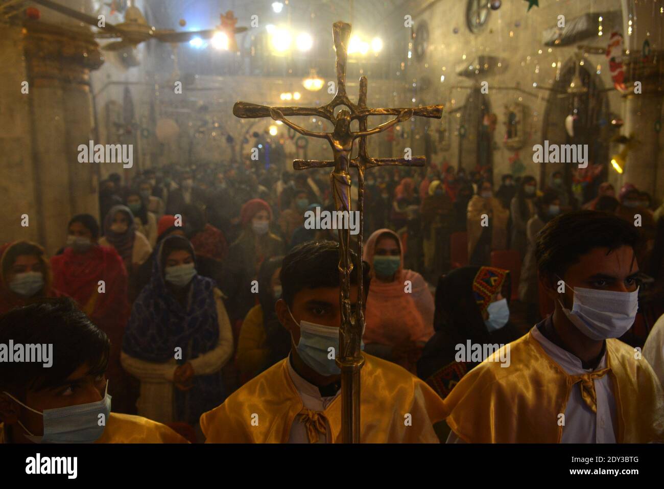 I cristiani pakistani adorano la messa di Natale di metà notte in vista delle celebrazioni natalizie nella Chiesa di Sant'Antonio a Lahore. Foto Stock