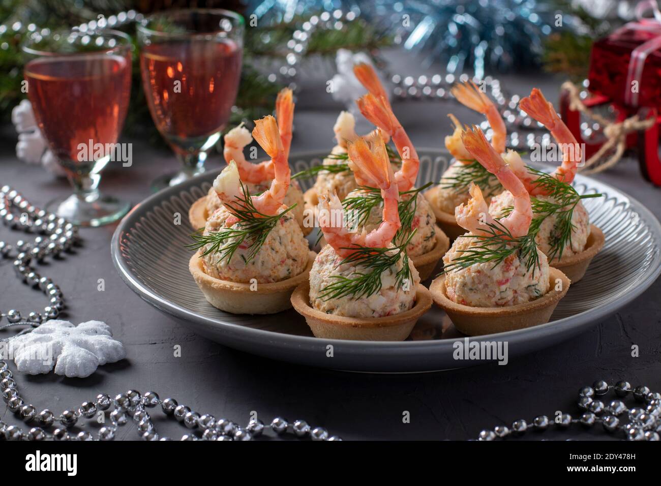 Tartlet con bastoncini di granchio, formaggio e gamberetti nella composizione del capodanno. Delizioso spuntino festivo. Primo piano Foto Stock