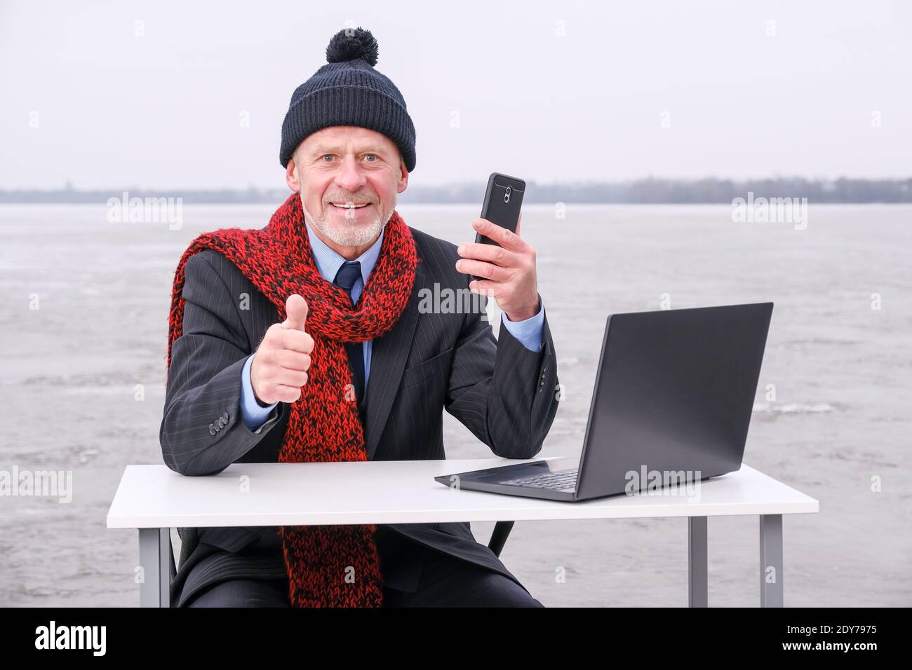uomo d'affari anziano con la bearded grigia in tuta, sorridente mentre parla sullo smartphone Foto Stock