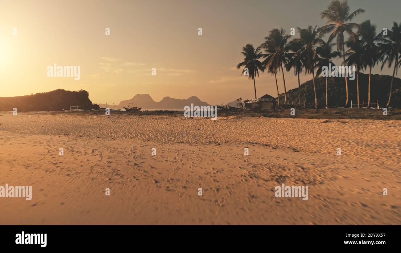 Spiaggia di sabbia del sole a baia dell'oceano con palme. Turisti vacanze estive in paradiso isola di El Nido Islet, Filippine, Asia. Incredibile nessuno tropico paesaggio naturale Foto Stock