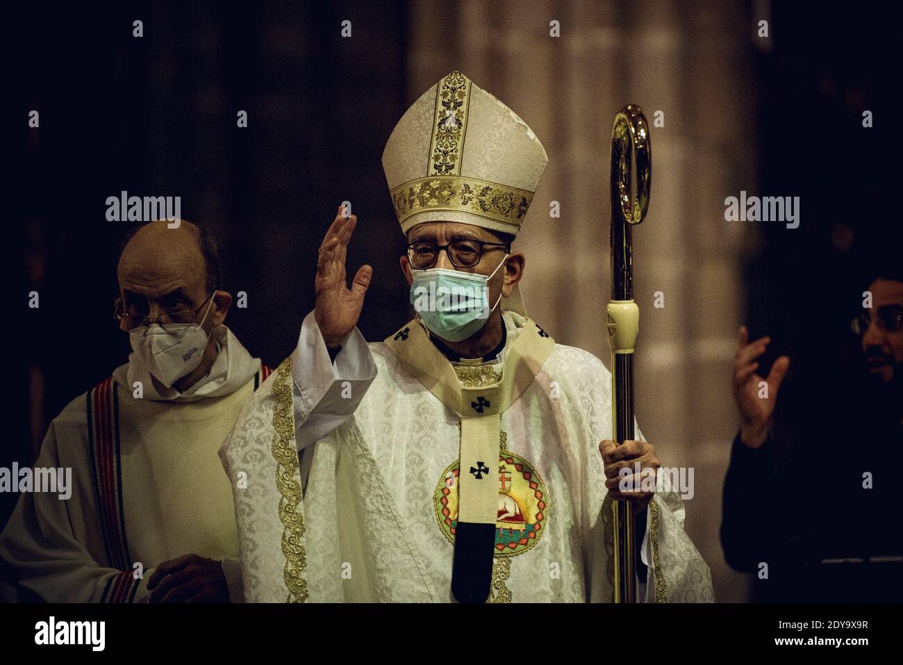 Barcellona, Spagna. 25 Dic 2020. IL Cardinale Arcivescovo di Barcellona, JOAN JOSEP OMELLA, cammina con il personale pastorale mentre parte alla fine della Messa della vigilia di Natale celebrata con una congregazione ecclesiastica fortemente ridotta sotto stretta misura igienica a causa della continua diffusione del virus COVID-19. Credit: Matthias Oesterle/Alamy Live News Foto Stock