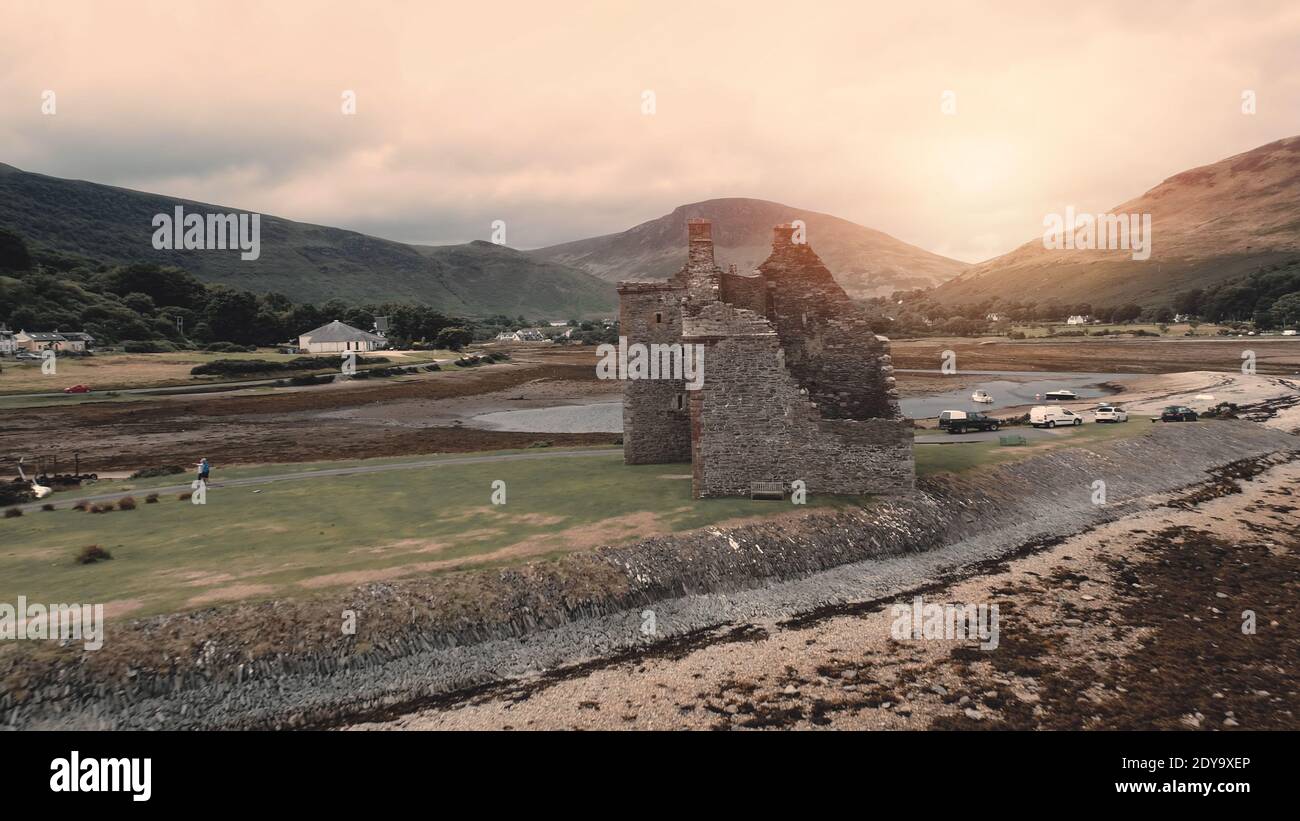 Closeup rovine del castello aereo. Il sole sopra l'attrazione storica di architettura a Sea Bay. Monumento storico e patrimonio. Oceano costa con marinai sul lago. Loch-Ranza, isola di Arran, Scozia, Europa Foto Stock