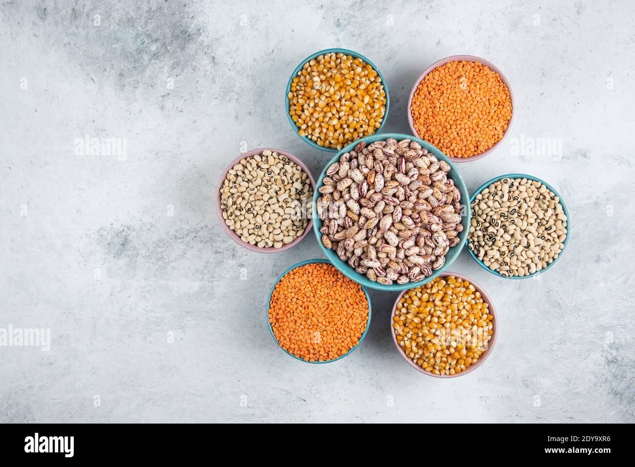 Ciotola grande dei fagioli marroni intorno ai fagioli grezzi vari e. lenticchie Foto Stock