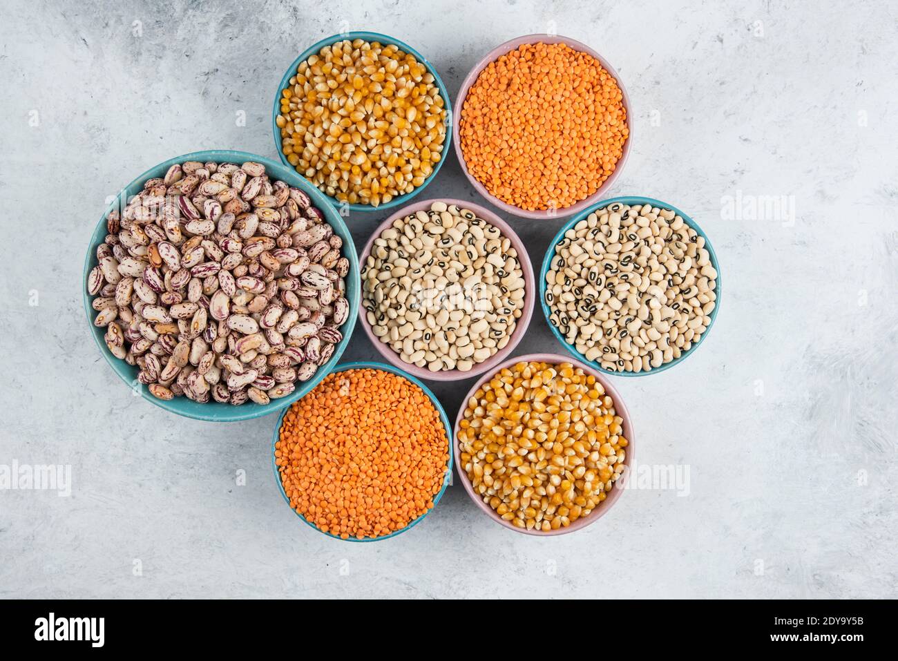 Mazzetto di fagioli, cornetti e lenticchie rosse non cotti in ciotole Foto Stock