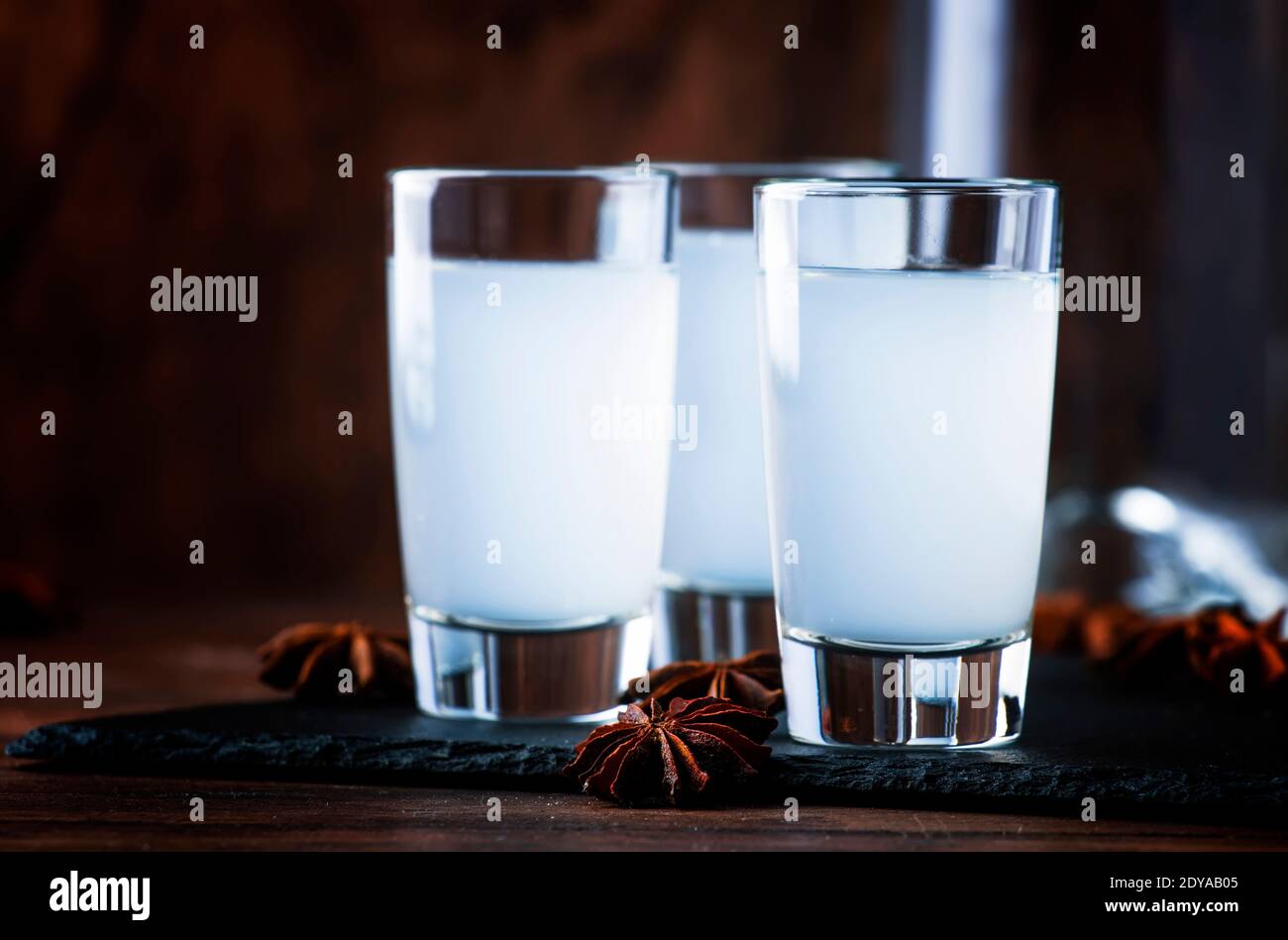 Ouzo - acquavite di anice greco, bevanda alcolica forte tradizionale in bicchieri sul vecchio tavolo di legno, posto per il testo Foto Stock