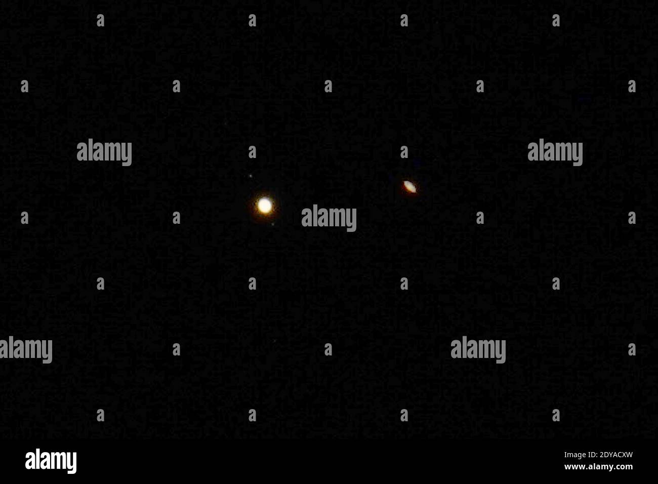 Giove (a sinistra) e Saturno sono visti nel cielo, lunedì 21 dicembre 2020, sopra Los Angeles. I due pianeti sono nel loro allineamento osservabile più vicino dal 1226. L'allineamento noto come "grande congiunzione" è stato anche chiamato "Stella di Natale", a differenza di un decimo di grado di distanza. Foto Stock