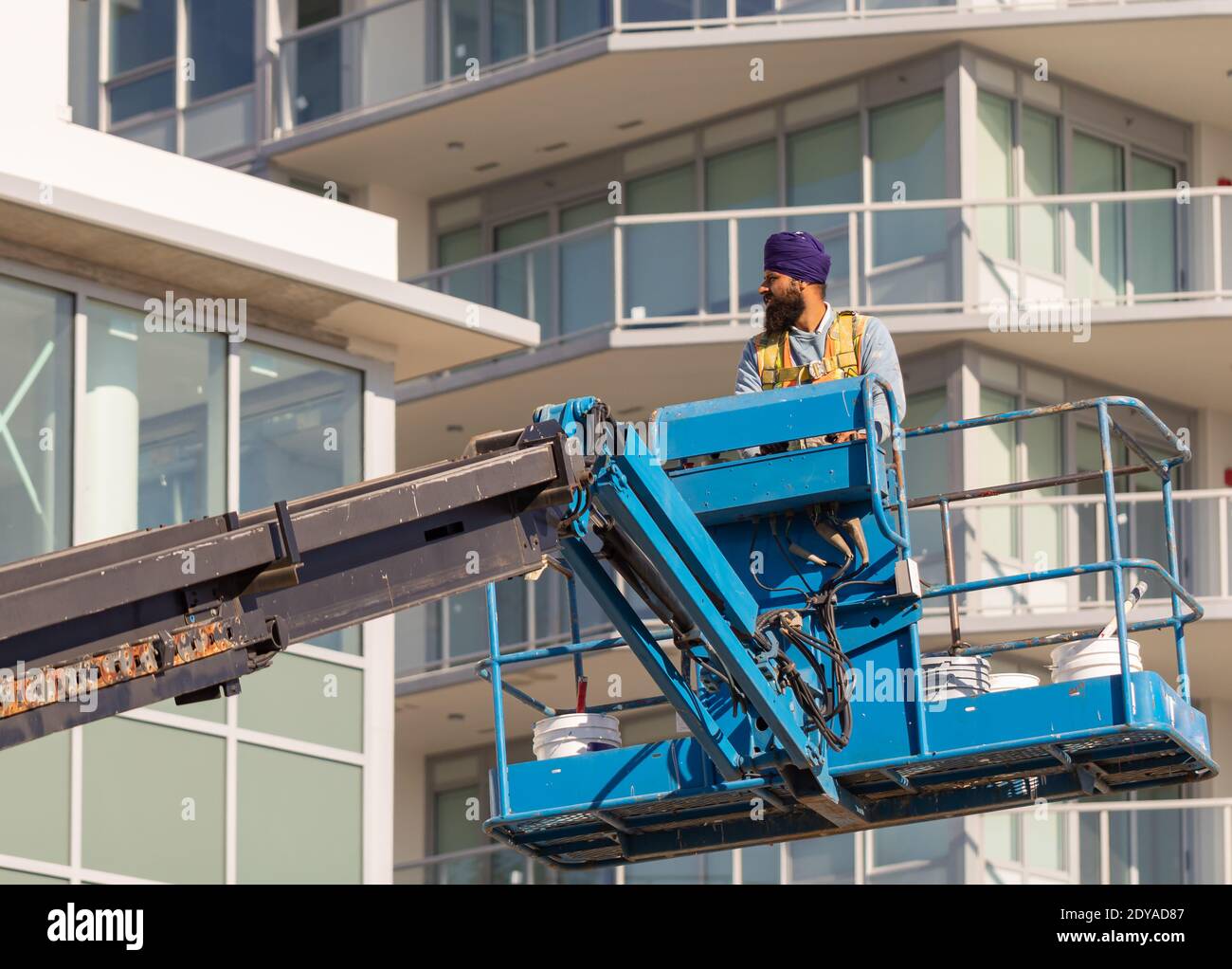 Operatore di costruzione in piedi nella benna della gru mobile. White Rock, British Columbia/Canada, ottobre 22,2020. Messa a fuoco selettiva, foto di strada, concetto p Foto Stock