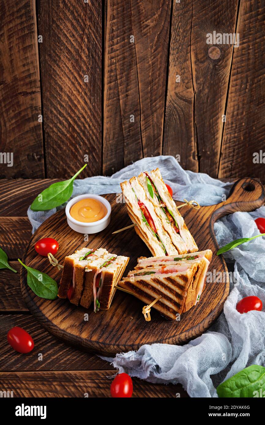 Club sandwich con prosciutto, pomodoro, formaggio e spinaci. Panini alla griglia Foto Stock