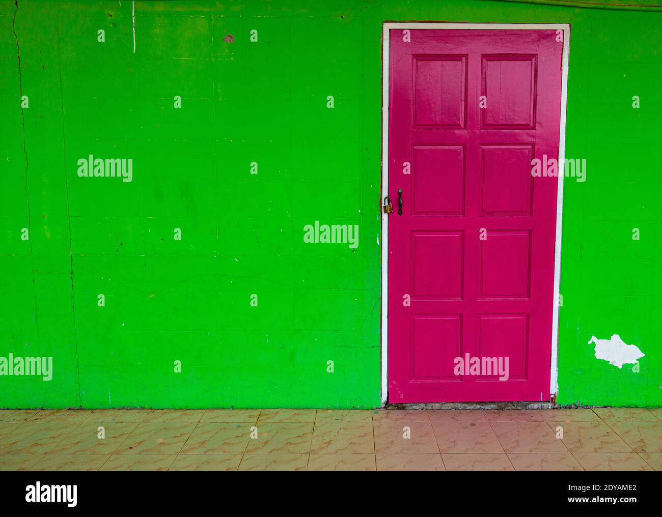 Parete verde con sportello rosa brillante, con spazio per la copia. Foto Stock