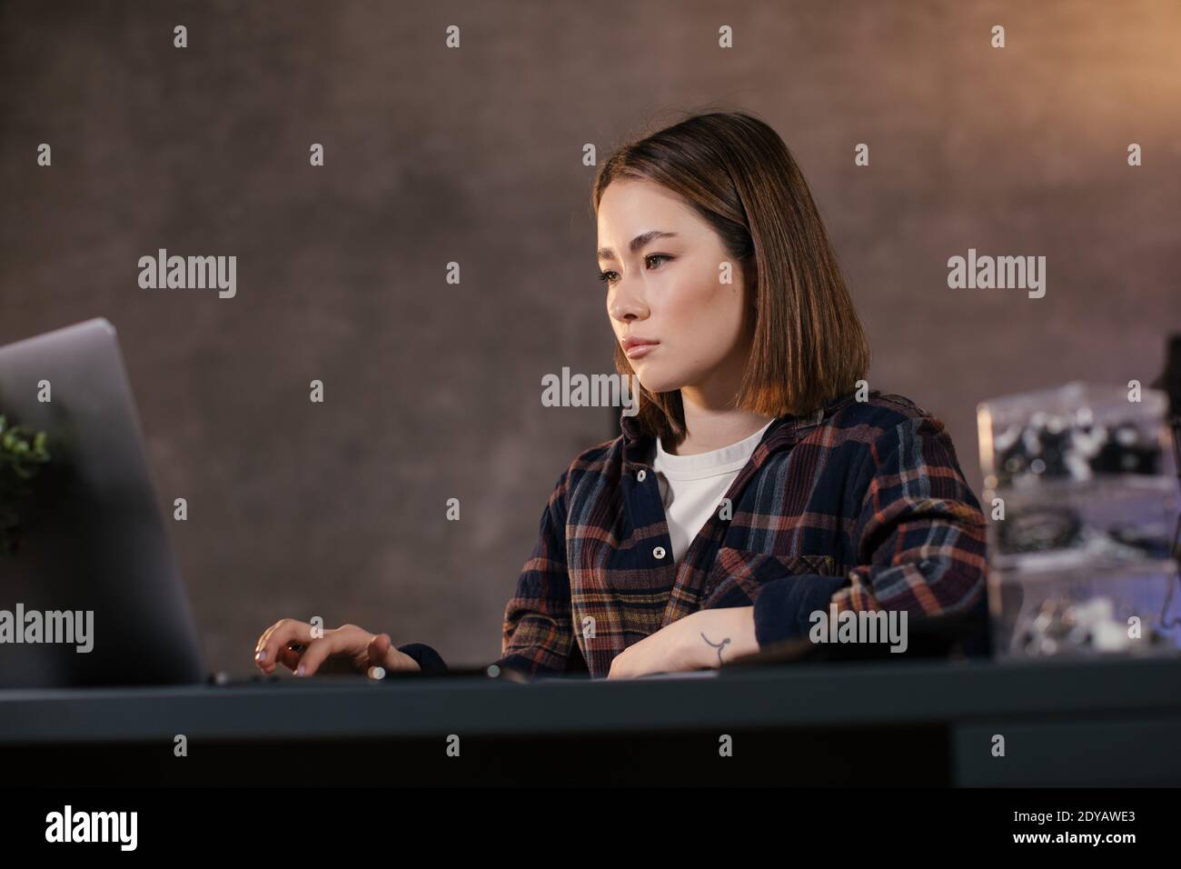Asian ragazza trader che lavora su un portatile a casa Foto Stock