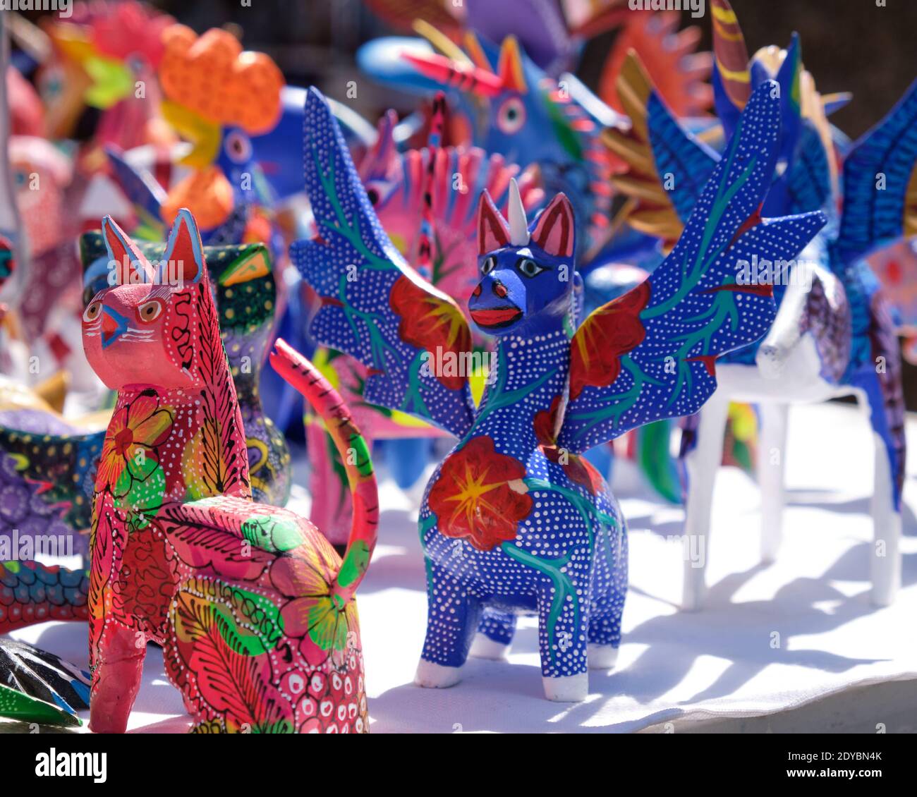Un Alebrijes, sculture whimsical raffiguranti un immaginario alato creature dipinte con colori intensi e intricati modelli sul tavolo del mercato in Messico Foto Stock
