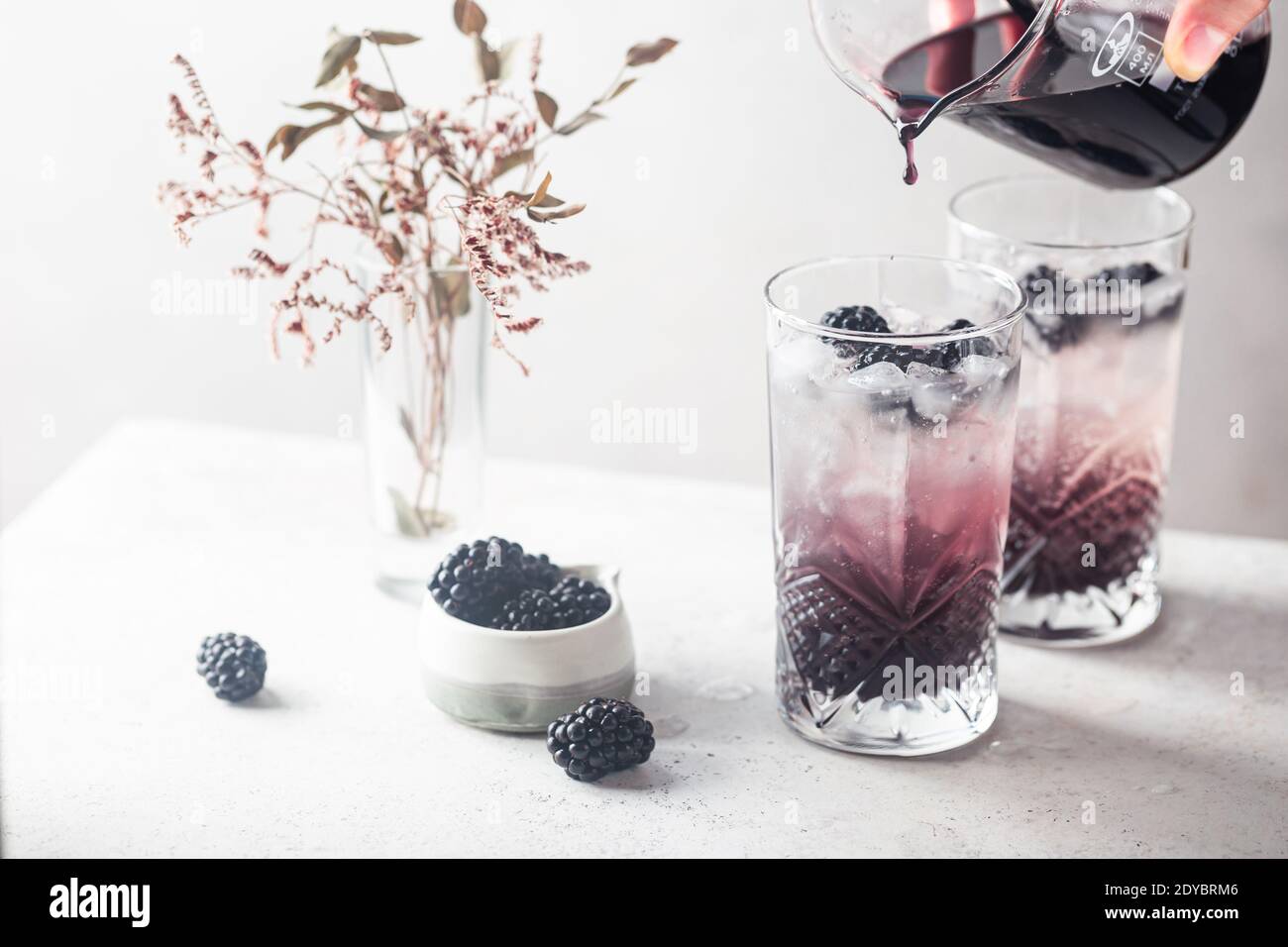 Rinfrescare BlackBerry Lemonade con ghiaccio in bicchieri di cristallo su sfondo bianco Foto Stock