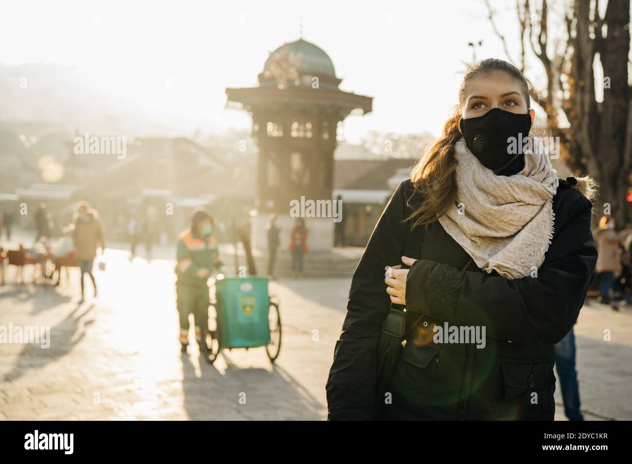 Giovane donna che indossa una maschera protettiva con una valvola. Vivere nella città inquinata. Coronavirus COVID-19 pandemie maschere obbligatorie su spazi pubblici.Busy c Foto Stock