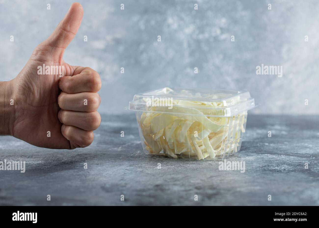 Mano dell'uomo che gestura il pollice fino al formaggio fresco Foto Stock