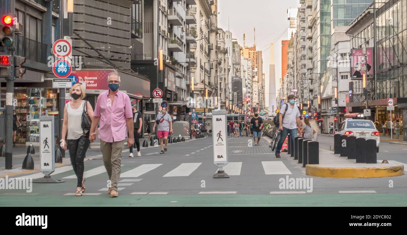 Persone in maschere di faccia, durante la passeggiata pandemica Covid-19 lungo Corrientes Avenue a Buenos Aires, Argentina Foto Stock