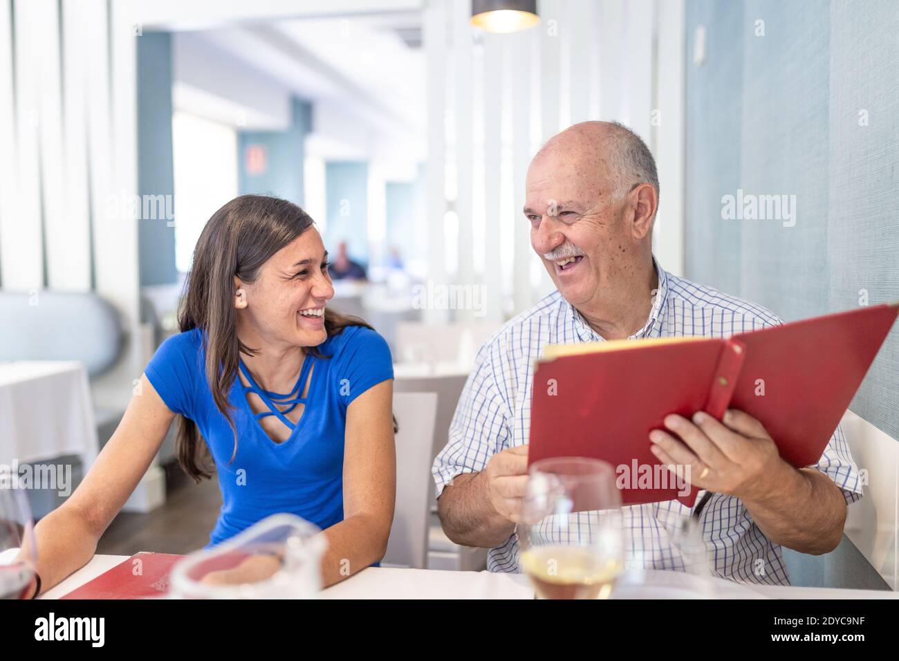 L'uomo maturo e la giovane donna si divertono e sorridono, trascorrendo il tempo insieme Foto Stock
