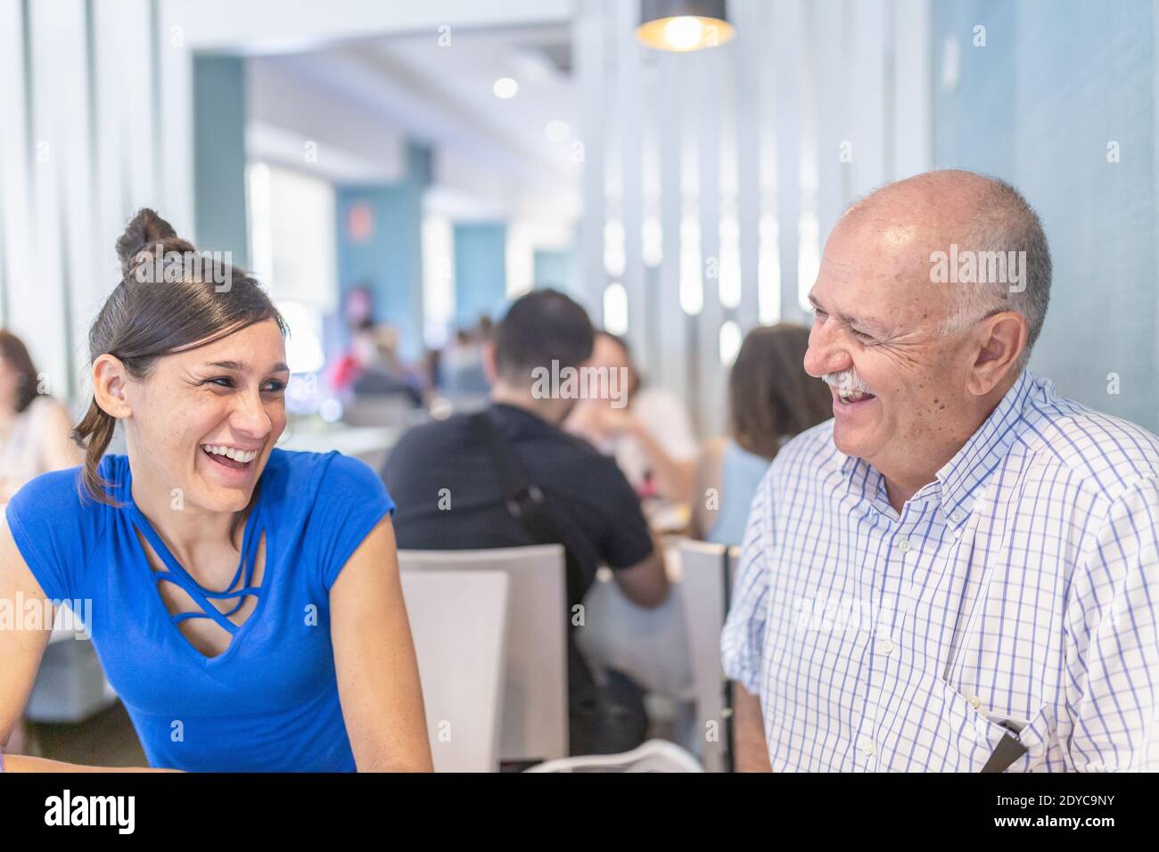 L'uomo maturo e la giovane donna si divertono e sorridono, trascorrendo il tempo insieme. Foto Stock