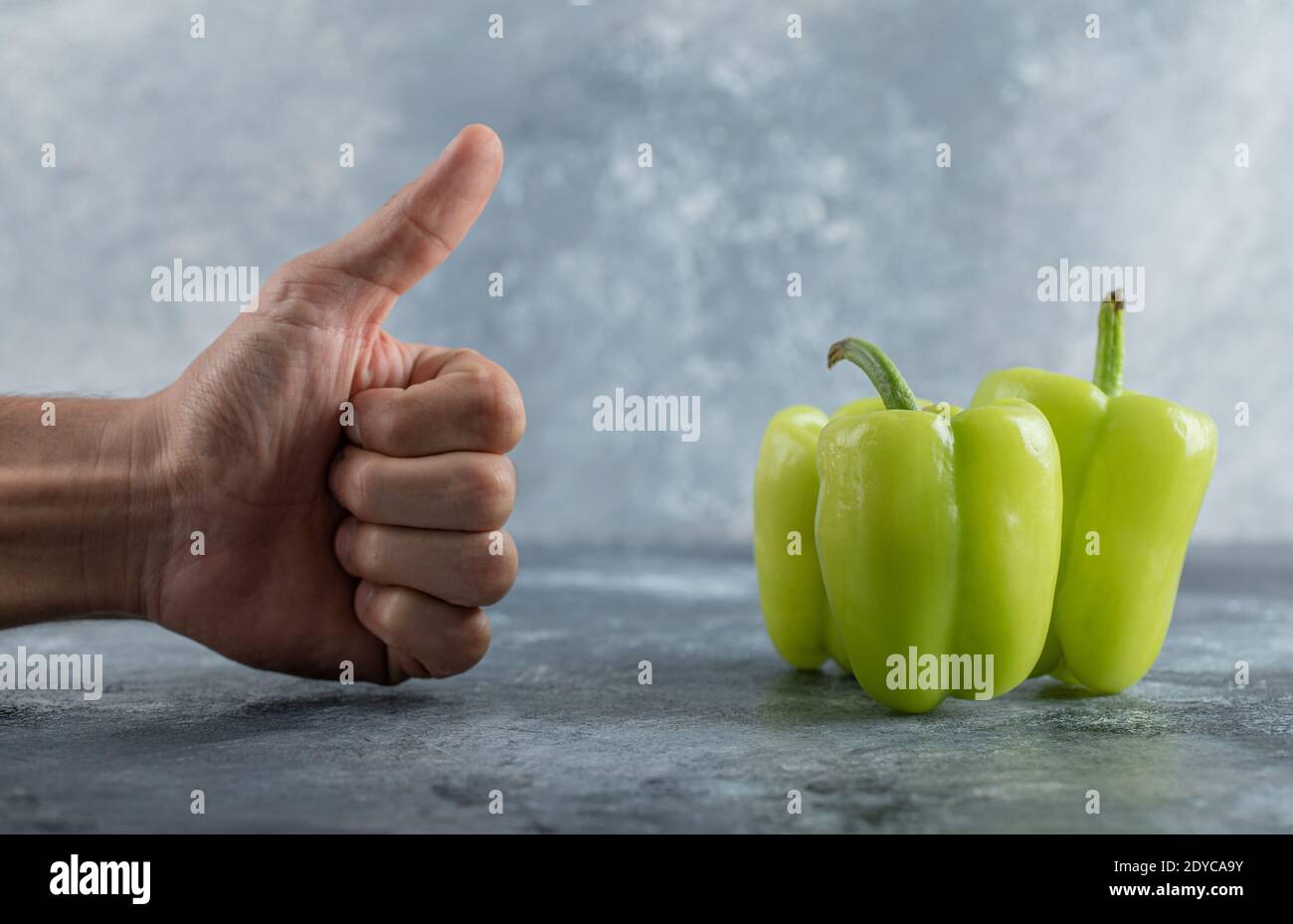 Uomo gesturing pollice su il peperone verde dolce Foto Stock