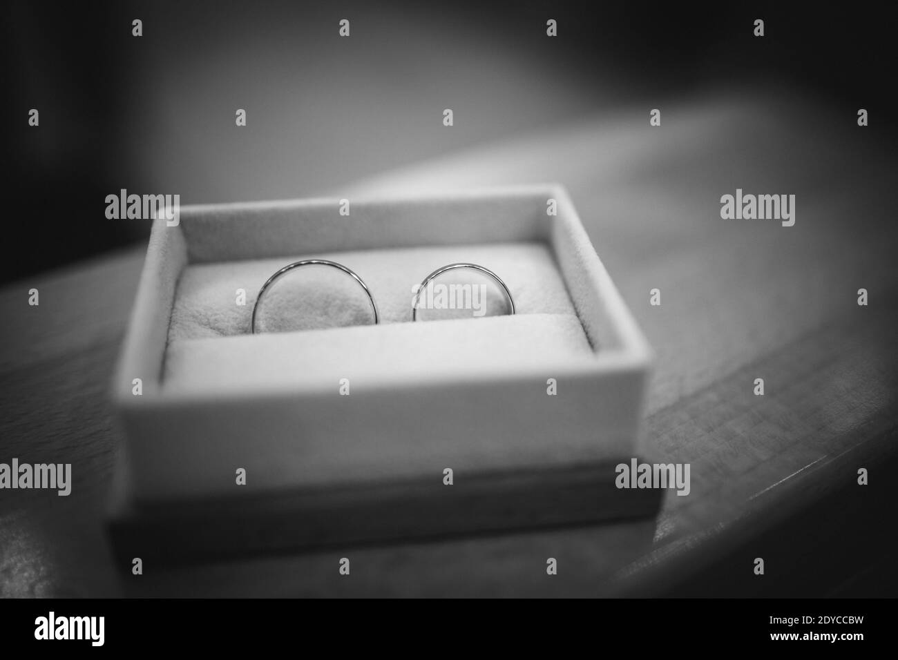 Una scala di grigi di anelli di nozze in una scatola bianca Foto Stock