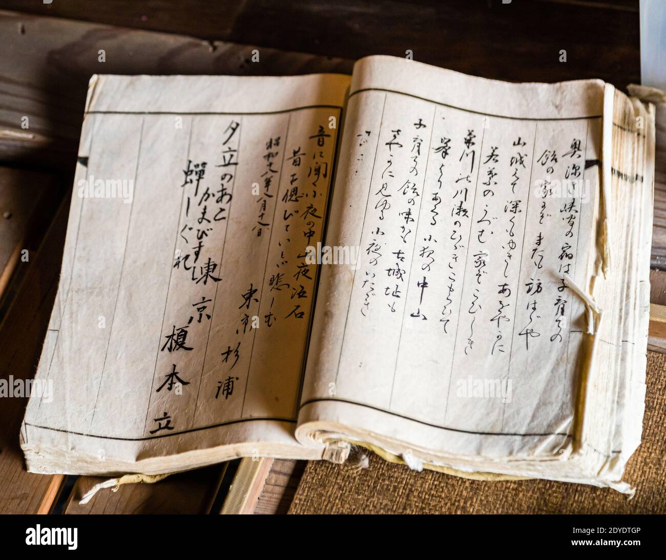 Un antico libro manoscritto di poesie giapponesi è aperto in un negozio di souvenir alla stazione postale di Nissaka-juku vicino a Kakegawa, Giappone. Foto Stock