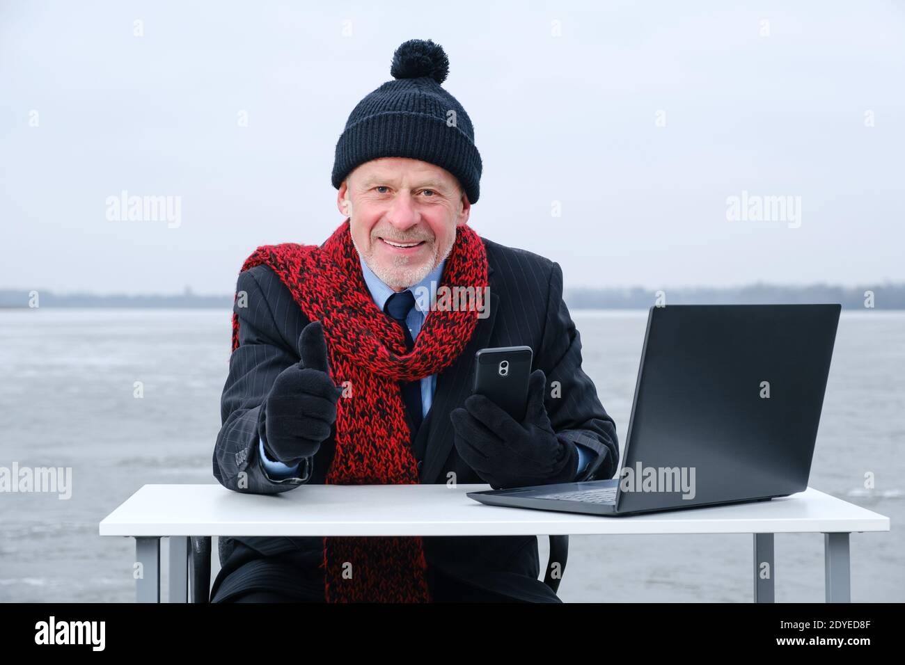 uomo d'affari anziano con la bearded grigia in tuta, sorridente mentre parla sullo smartphone Foto Stock