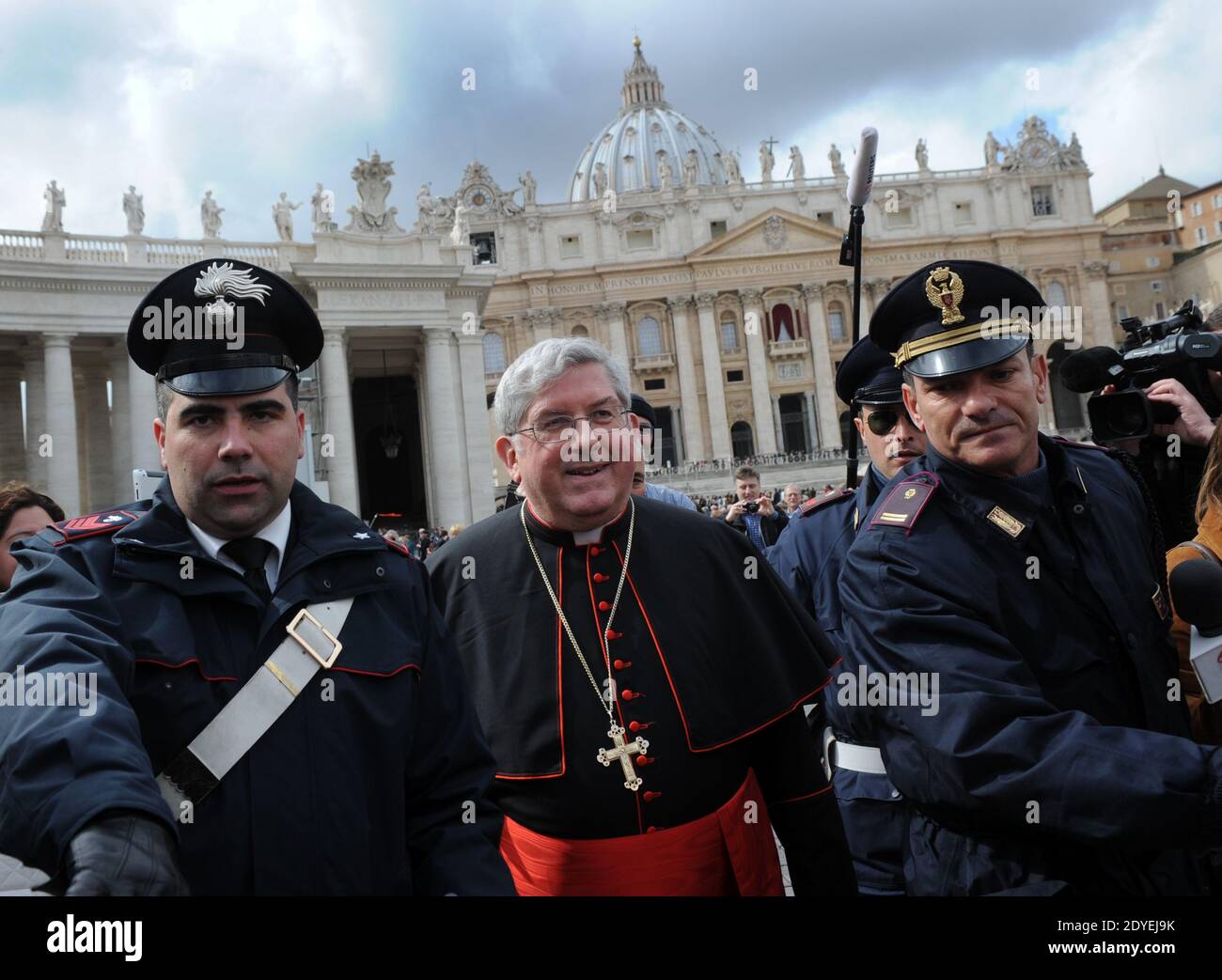 Il Cardinale canadese Thomas Christopher Collins è seguito da poliziotti, giornalisti e turisti mentre cammina in Piazza San Pietro in Vaticano il 11 marzo 2013. I Cardinali di tutto il mondo si sono riuniti in Vaticano per l'ultimo incontro prima del conclave per eleggere il prossimo papa. Foto di Eric Vandeville/ABACAPRESS.COM Foto Stock