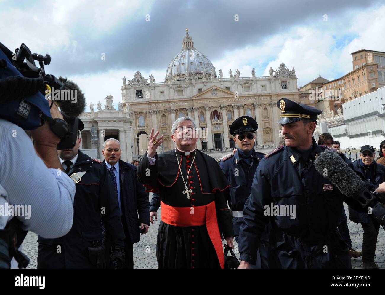 Il Cardinale canadese Thomas Christopher Collins è seguito da poliziotti, giornalisti e turisti mentre cammina in Piazza San Pietro in Vaticano il 11 marzo 2013. I Cardinali di tutto il mondo si sono riuniti in Vaticano per l'ultimo incontro prima del conclave per eleggere il prossimo papa. Foto di Eric Vandeville/ABACAPRESS.COM Foto Stock