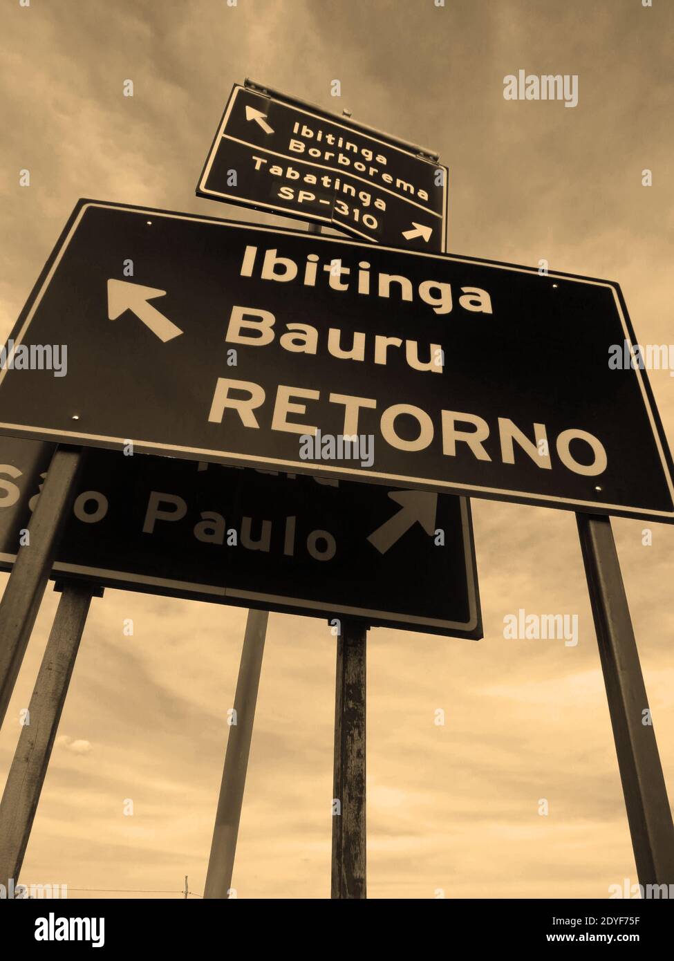 Gruppo di cartelli metallici che indicano più posizioni in un fusibile Strada nella campagna brasiliana [Seppia] Foto Stock