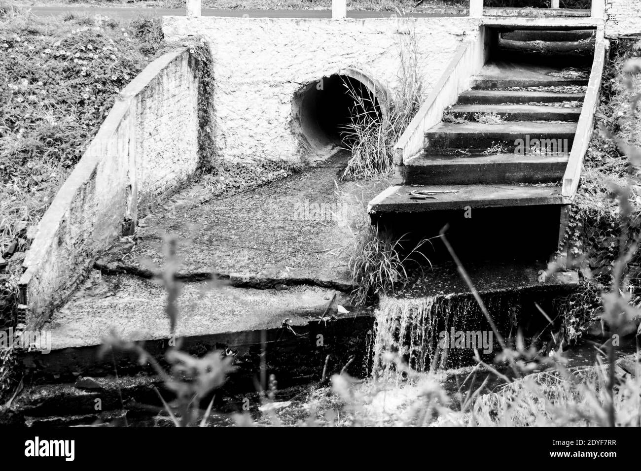 Fogna buco che espelle l'acqua al fiume in una campagna villaggio Foto Stock